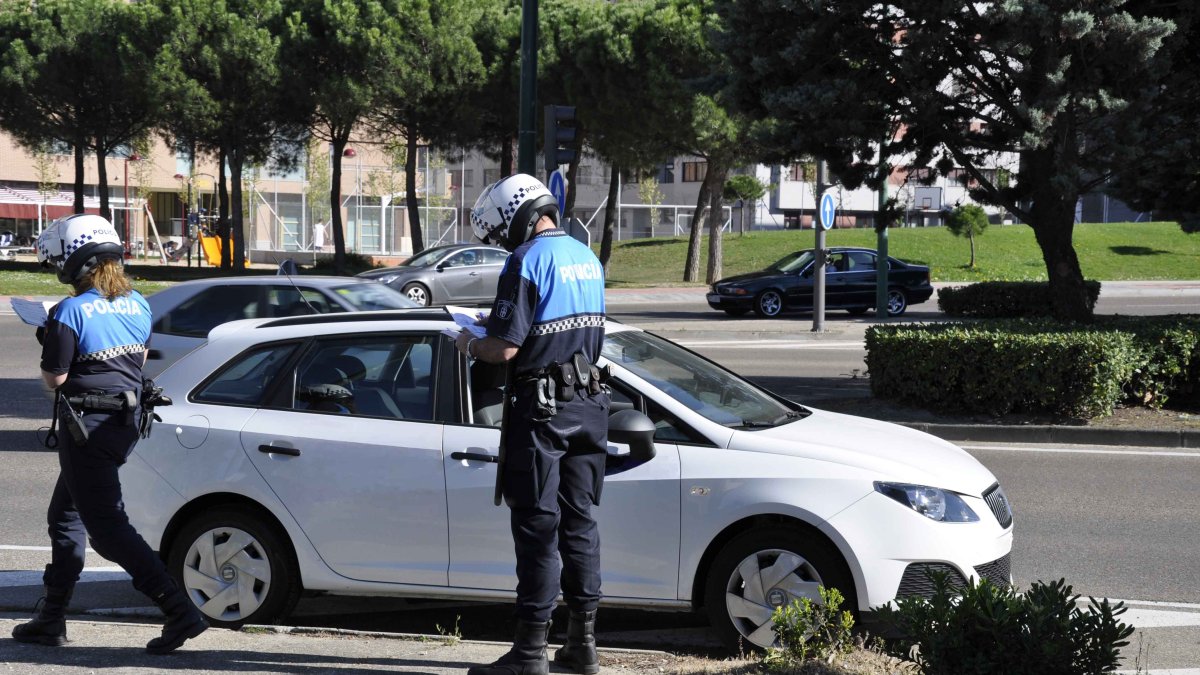 Dos policías multan a un coche parado en una calle de Valladolid.