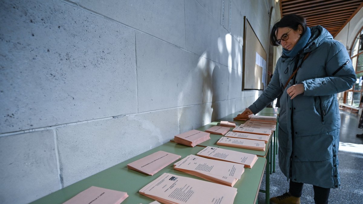 Una persona elige papeleta en un colegio electoral.