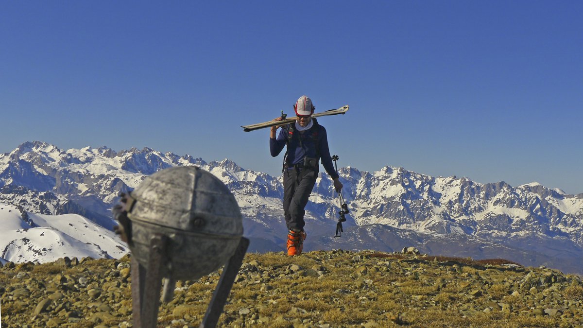 Un montañero alcanza la cumbre del Pico Lezna con los Picos de Europa al fondo