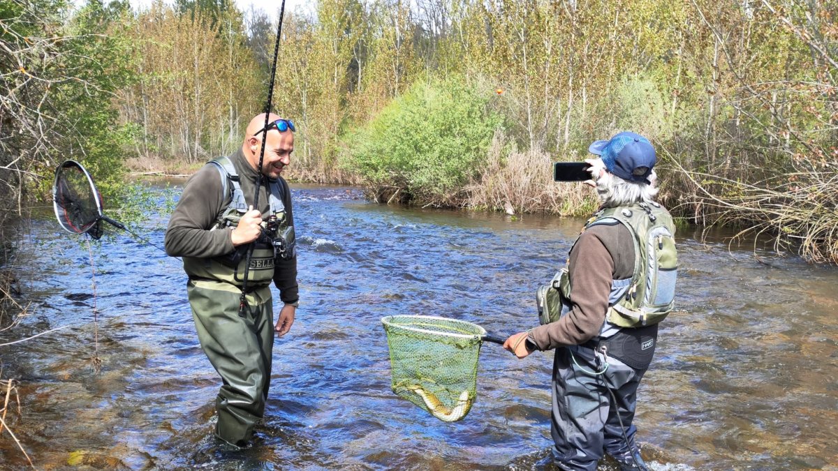 Dos aficionados con una buena trucha en la Tabla de Los Antolines del río Carrión palentino.
