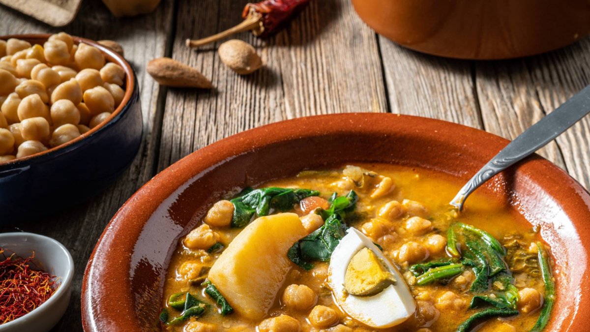 El potaje de vigilia, con garbanzos, espinacas y bacalao, es uno de los guisos más tradicionales de la Cuaresma, servido aquí con huevo cocido en plato de barro