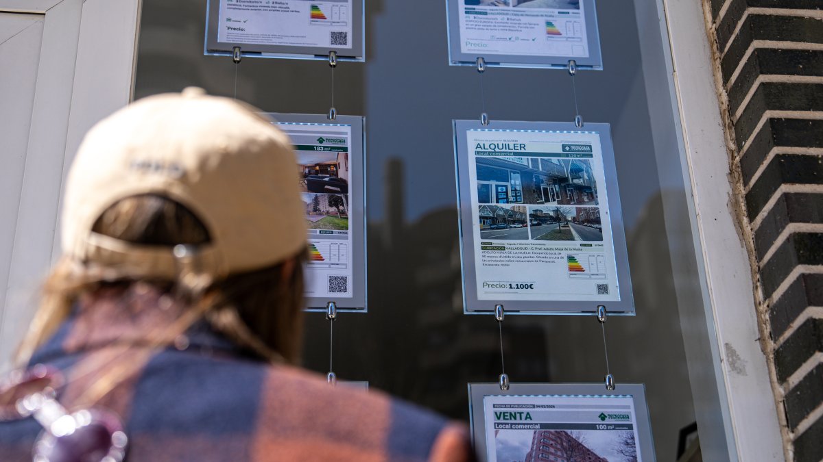 Una persona observa los anuncios en el escaparate de una inmobiliaria.