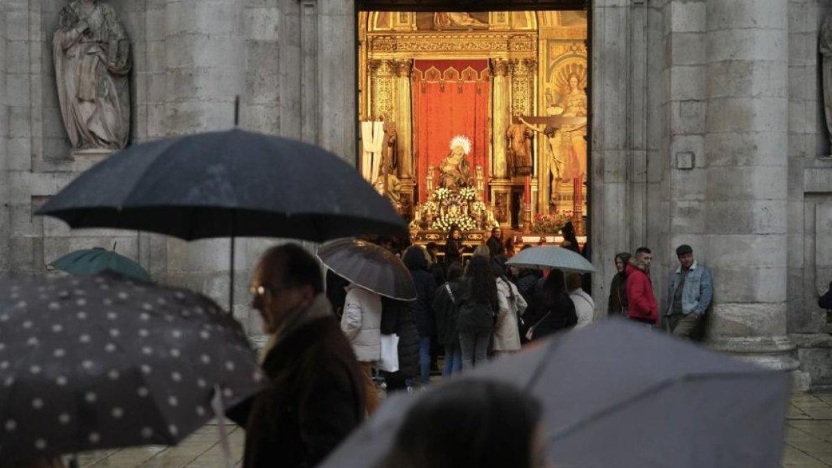 Vallisoletanos con paraguas junto a la 'Virgen de las Angustias' en la edición de 2024
