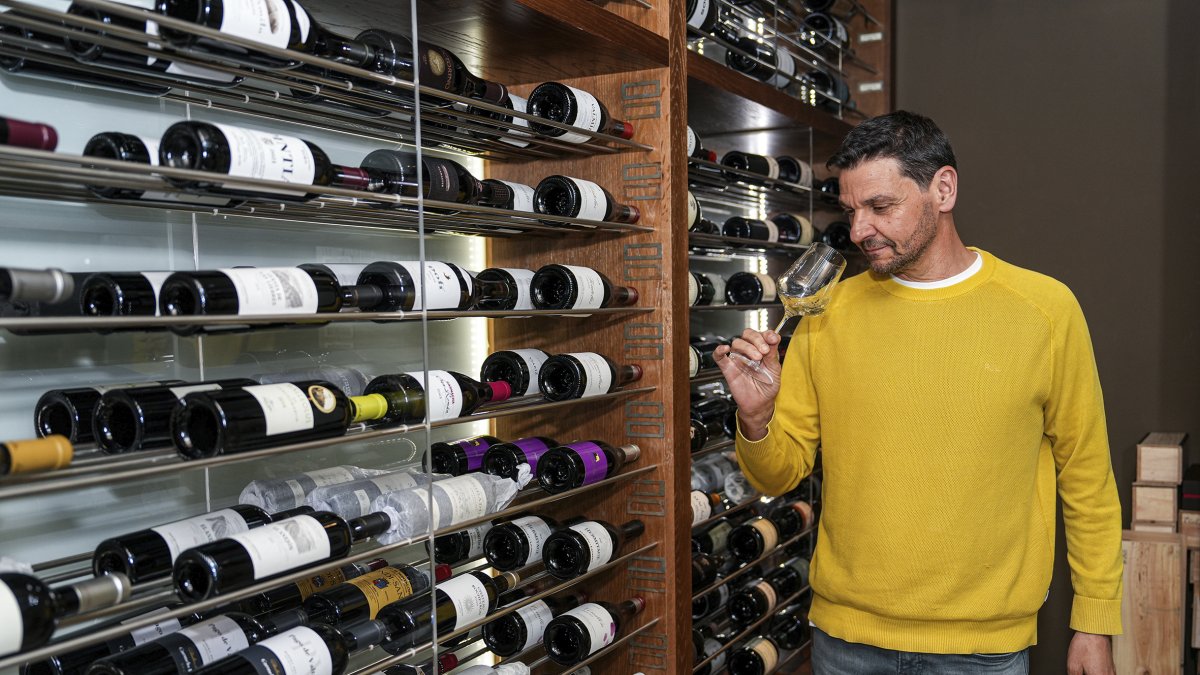 Fructuoso cata un vino ante la cava climatizada.