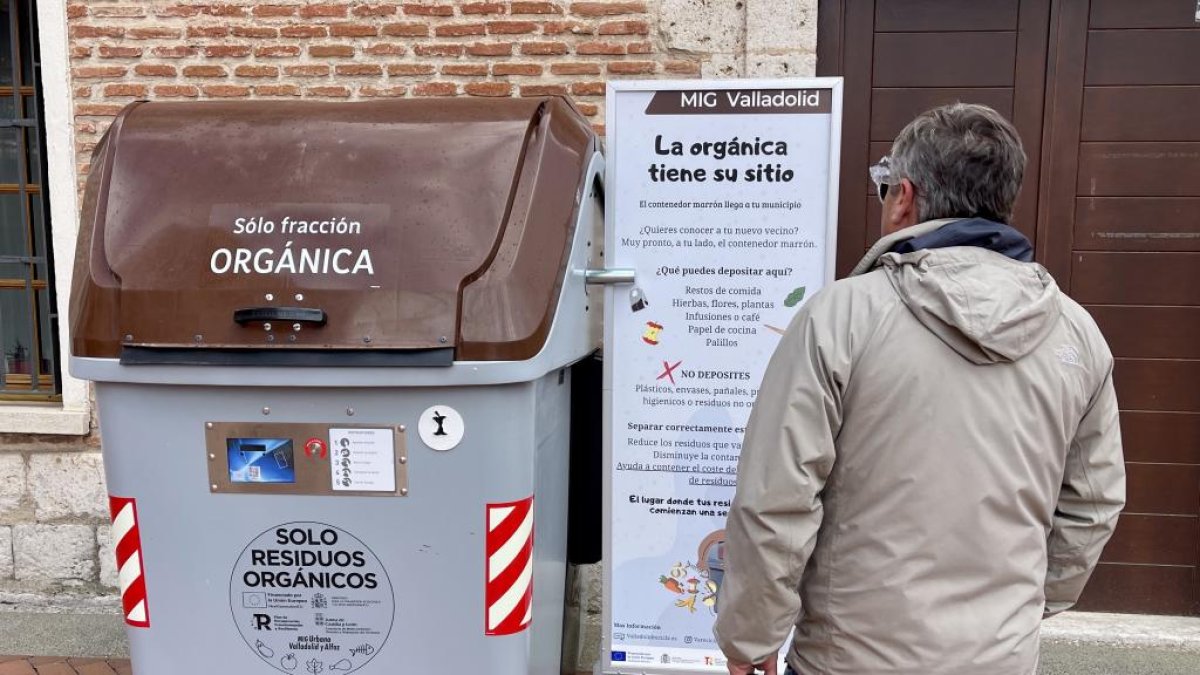 Un vecino de Laguna de Duero lee el cartel informativo que han colocado junto al nuevo contenedor.