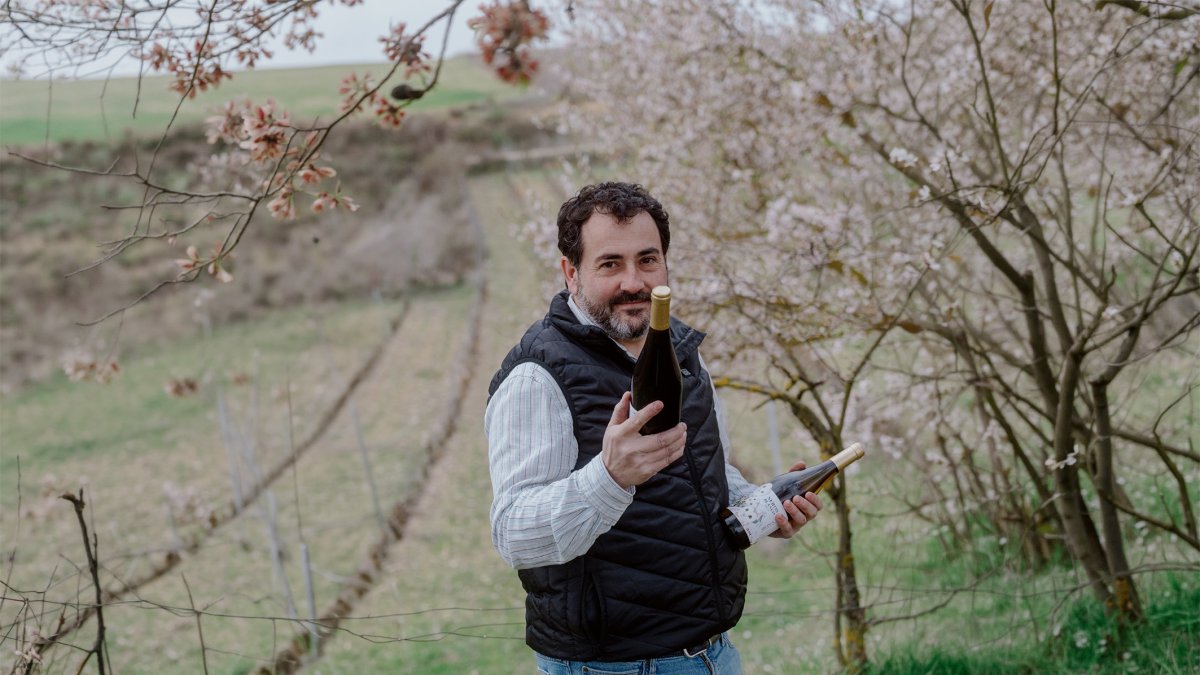 Rubén Montero, en sus viñedos, con una botella de Neros Blanco
