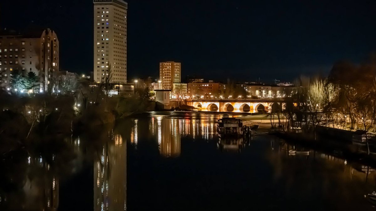 La iluminación nocturna junto al Pisuerga transforma el entorno del Puente Mayor en uno de los paisajes urbanos más fotografiados de Valladolid.