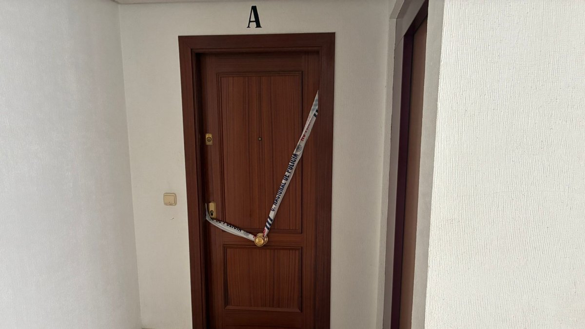 Imagen de la puerta de la vivienda en la que se hallaron los cadáveres