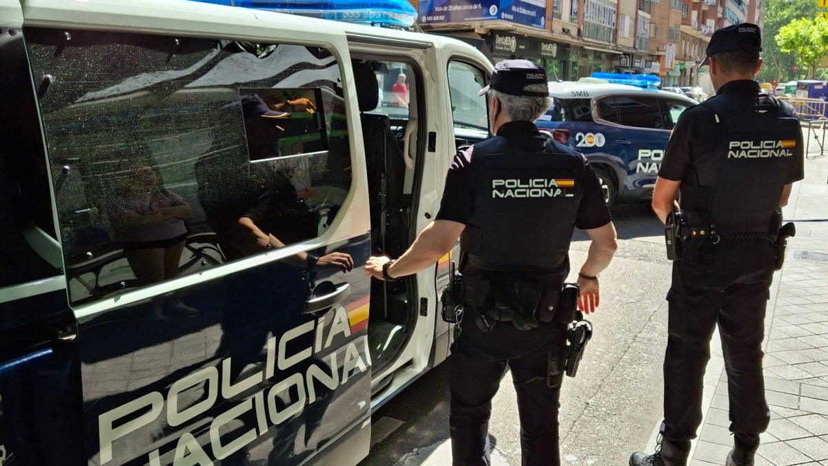 Dos agentes de la Policía Nacional delante de un furgón