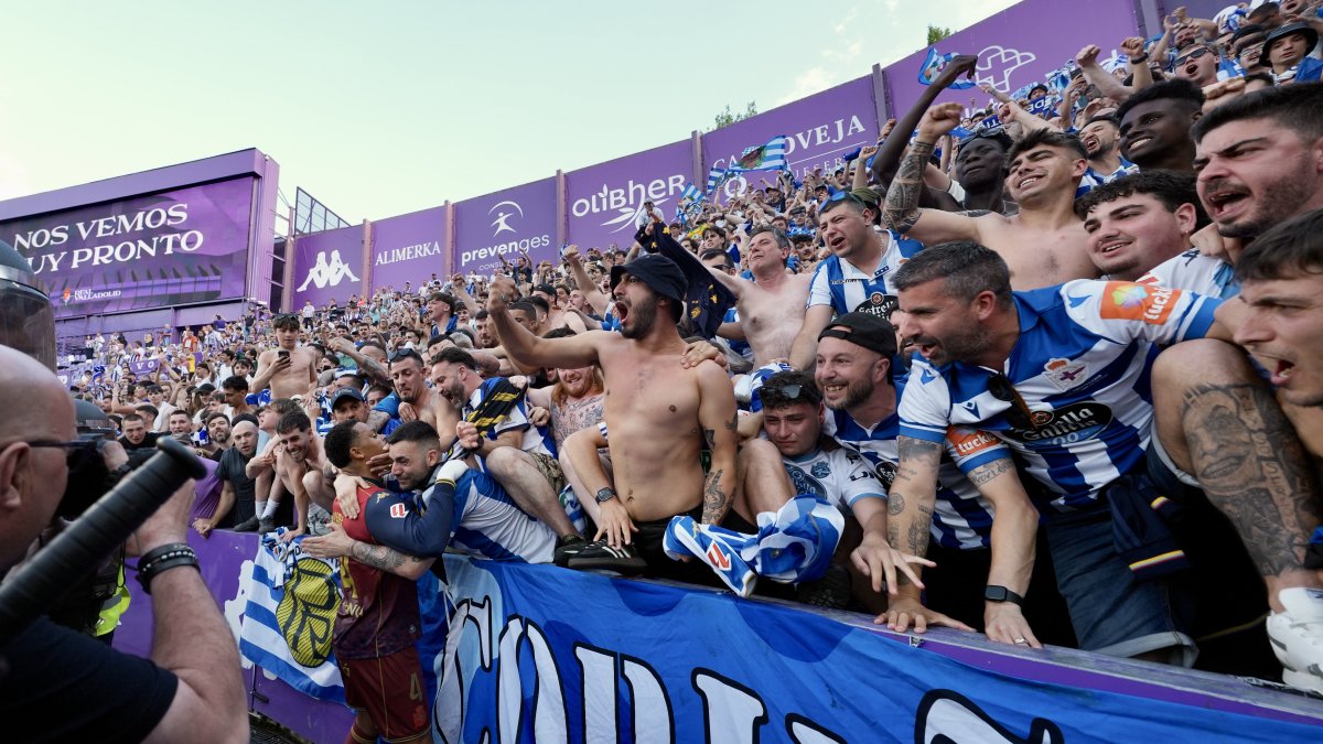 Aficionados del Deportivo abrazan a uno de sus jugadores tras el ascenso.