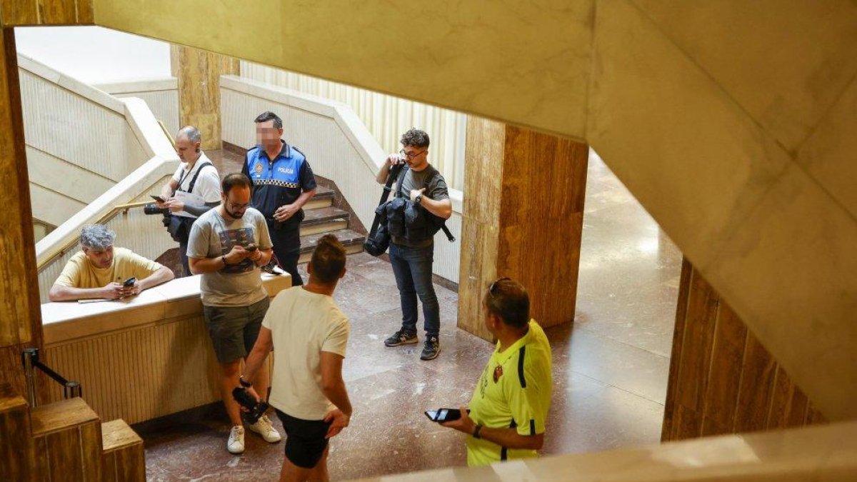 Varios informadores de los medios de comunicación esperan en el Ayuntamiento de Soria mientras la Guardia Civil registra varias dependencia por orden judicial.