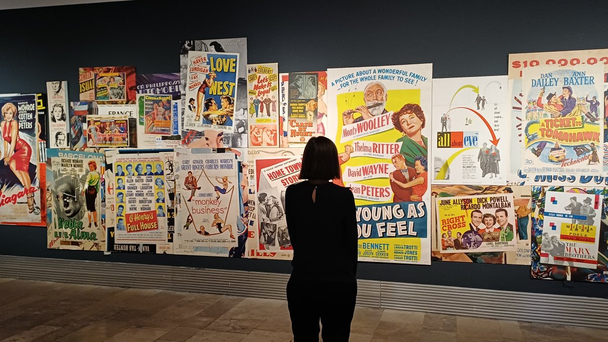 Una mujer contempla carteles de películas de Marilyn Monroe