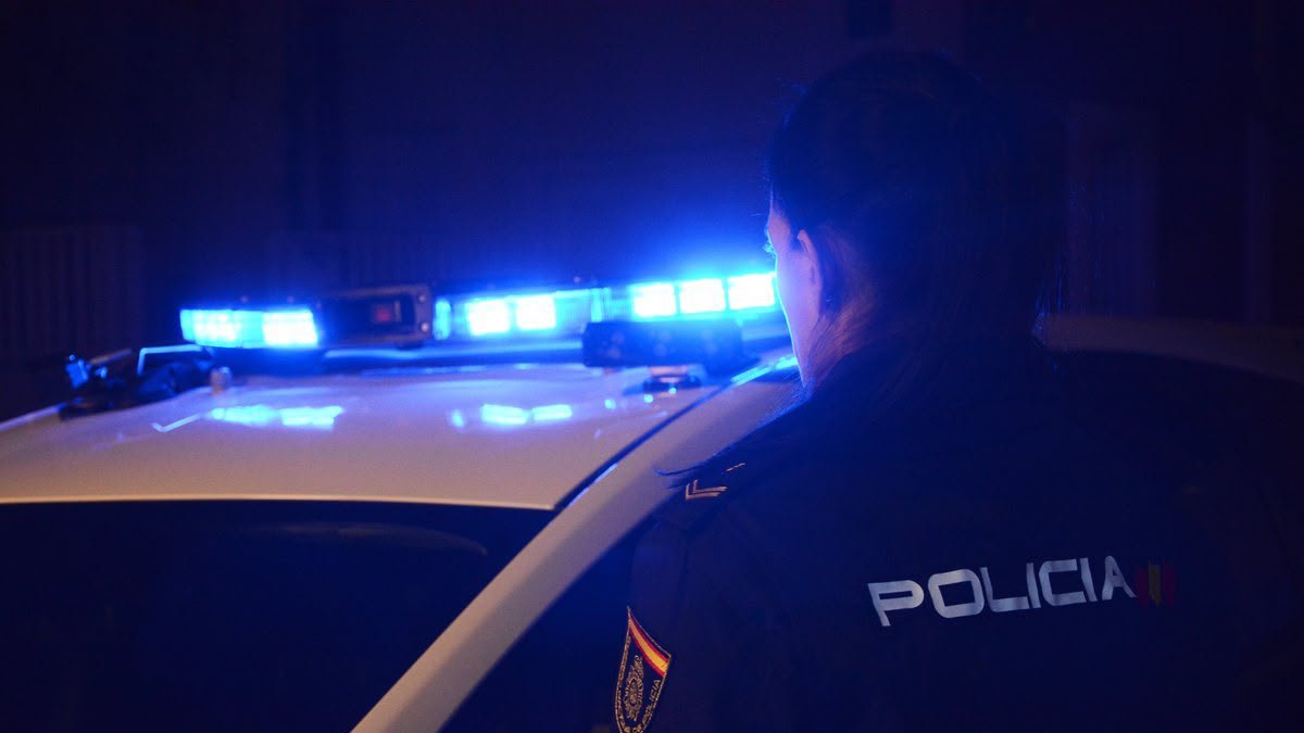 Un Policia Nacional junrto al coche de Cuerpo Nacional de Policía