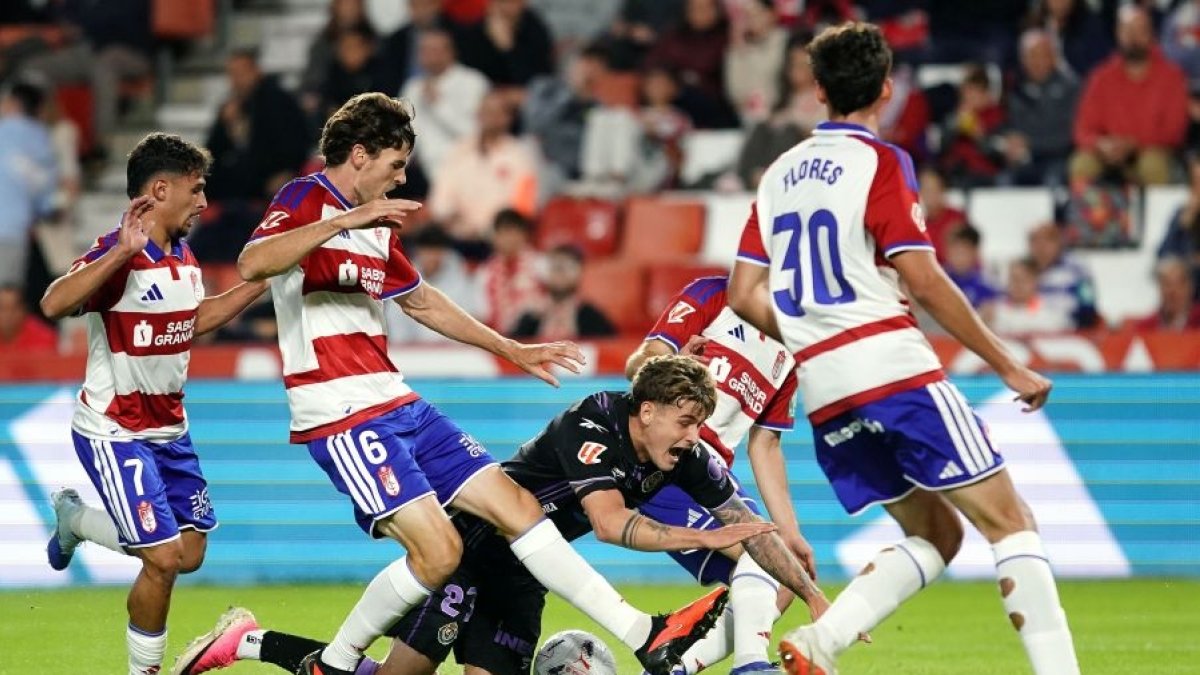 El lateral izquierdo Garri, autor del gol blanquivioleta en Los Cármenes, cae rodeado de jugadores del Granada.
