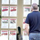 Un vecino observa las ofertas de pisos en venta y alquiler en una inmobiliaria de Valladolid. ICAL
