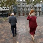 Una señora se protege de la lluvia con su bolso en la plaza de la Universidad