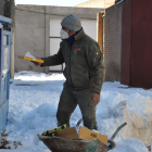 Un vecino de Fuente del Sol tira cartones al contenedor rodeado de nieve. SANTIAGO G. DEL CAMPO