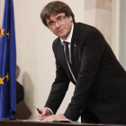 El president Carles Puigdemont en el momento de firmar la declaración, tras el pleno-JULIO CARBÓ