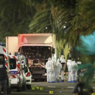 Un grupo de forenses examinan el camión del atentado, anoche en Niza.-