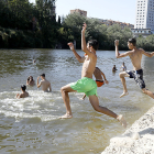 Un grupo de jóvenes se baña en la playa del Pisuerga este martes pese a no ser apta según la Junta. J.M. LOSTAU