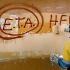 Un técnico de limpieza borra una pintada a favor de ETA en Gernika (Vizcaya), el día después de que la banda terrorista anunciase el cese definitivo de sus acciones armadas.-/ REUTERS / VINCENT WEST