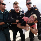 Un manifestante con una herida en la frente es agarrado por miembros de la Guardia Civil y la Policía Nacional-