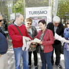 Visitantes consultan un folleto a la salida de la Oficina de Turismo de Valladolid de la Acera de Recoletos-J.M.Lostau