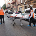 Dos operarios sacan a uno de los cadáveres del edificio en la calle Linares.- E.M.