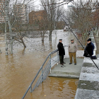 Tres hombres aprovechan la crecida del río para pescar en las inmediaciones del embarcadero, a orillas del paseo que recorre el parque de las Moreras.-J. M. Lostau