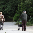 Una mujer y un hombre de edad avanzada pasen por la calle.- E. PRESS