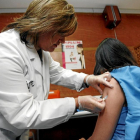 Una enfermera vacunando a una niña contra el virus del papiloma humano-EL MUNDO