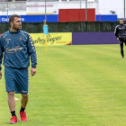 Chica anda en zapatillas por el césped de los Anexos ante la mirada de Rubi, durante el entrenamiento del lunes-Miguel Ángel Santos