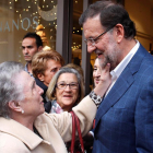 El presidente del Gobierno y candidato a la reelección por el PP, Mariano Rajoy, saluda a una mujer durante el recorrido que ha hecho hoy por las calles de Vigo, dentro de la campaña para las elecciones generales del 20D.-EFE
