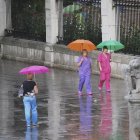 Varias personas se refugian en sus paraguas durante la lluvia.-MIGUEL ÁNGEL SANTOS