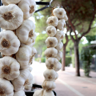 Ristras de ajo en el expositor de una feria tradicional del cultivo.