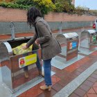 Una persona tira una bolsa de basura en un contenedor de Arroyo de la Encomienda.