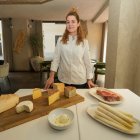 Gemma García, directora gastronómica de Raza, junto a una pieza de la carta de carnes, la tabla con seis tipos de diferentes quesos, el tomate a la brasa y gazpachuelo ahumado y un surtido de esparragos de temporada.