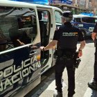 Dos agentes de la Policía Nacional delante de un furgón