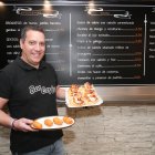 Alejandro Burgos muestra un plato con croquetas de huevo cocido y una bandeja con varias tapas de queso de cabra, mermelada  y cebolla caramelizada.