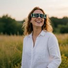 Una mujer utiliza las gafas homologadas para ver el eclipse.
