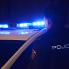 Un Policia Nacional junrto al coche de Cuerpo Nacional de Policía