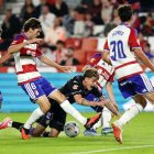 El lateral izquierdo Garri, autor del gol blanquivioleta en Los Cármenes, cae rodeado de jugadores del Granada.