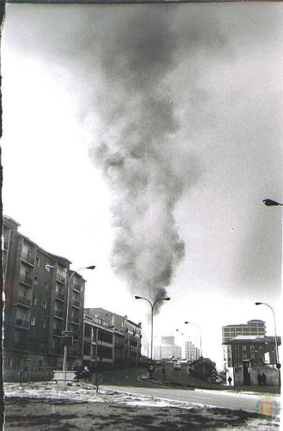 Una columna de humo se alza imponente sobre el Arco de Ladrillo junto a la calle San José en los años 70.
