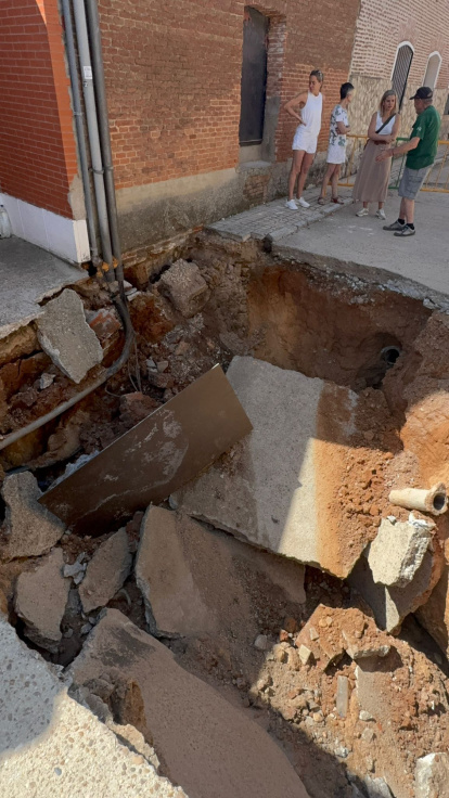 Vecinos de Rodilana observan en enorme socavón en la calle Murga del barrio periférico de Medina del Campo.