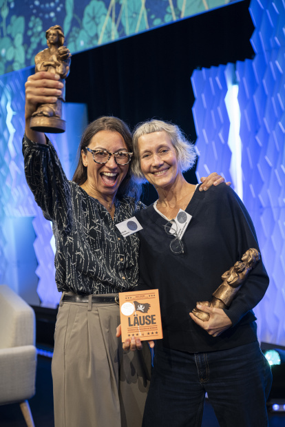 La autora palentina y su traductora posan con el galardón y el libro.